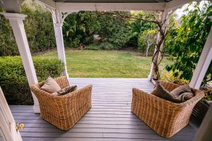 three wicker chairs sitting on a porch at Cape South Estate - International award-winning country estate with Pacific views in Havelock North