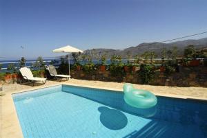 una piscina con una sedia di plastica blu di Villa Mousses with Private Pool a Mochlos