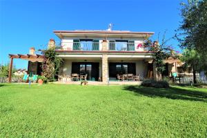 uma casa com um relvado em frente em Villa di Marinella em Ascea