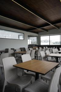 a dining room with tables and chairs and windows at Hotel Principal in Mexico City