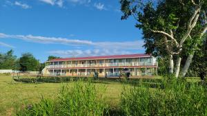 un bâtiment avec un toit rouge dans un champ dans l'établissement Bouctouche Bay Inn, à Bouctouche