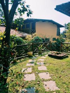 un giardino con sentiero in pietra di fronte a una casa di Pousada Aquarela do Mar a Abraão