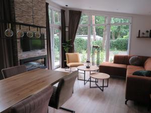 - un salon avec une table en bois et une cheminée dans l'établissement Lovely bungalow in Hoenderloo with fireplace, à Hoenderloo