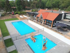 Výhled na bazén z ubytování Lovely bungalow in Hoenderloo with fireplace nebo okolí