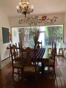 a dining room with a table and chairs and a chandelier at Hostal Cuija Coyoacan Berlin 268 Coyoacan in Mexico City