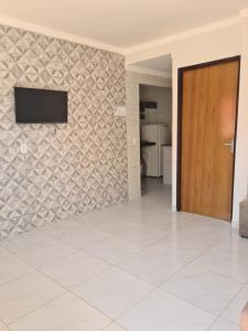 ein Wohnzimmer mit einem Fernseher an der Wand in der Unterkunft Apartamento familiar aconchegante in Maragogi + 26 Fotos