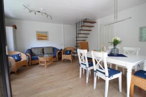 a dining room with a white table and chairs at Reethaus Ostseestrand 15 in Wustrow