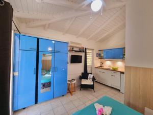ein Wohnzimmer mit einem blauen Schrank und einer Küche in der Unterkunft Gites Kaladja in Port-Louis