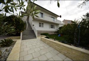 ein weißes Haus mit einer Treppe davor in der Unterkunft Apartment Sveto - 400 m from beach in Biograd na Moru
