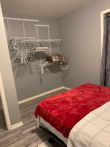 a bedroom with a bed with a red blanket at Ottawa airport guesthouse in Ottawa
