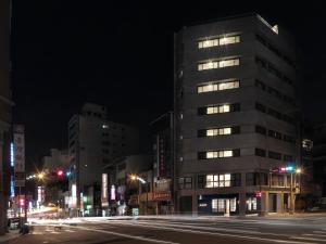 Un palazzo alto in una strada di città di notte di Mr.Mantter a Taichung