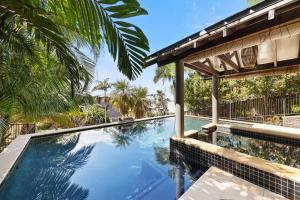 a swimming pool in front of a house at Coolum OCEAN VIEWS, Oasis Pool, Cinema & Games Room in Coolum Beach