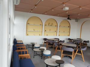 a room with tables and chairs and shelves at Sambina Prime by Danapati in Jakarta