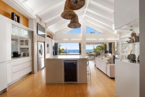 a kitchen and living room with a view of the ocean at Coolum OCEAN VIEWS, Oasis Pool, Cinema & Games Room in Coolum Beach