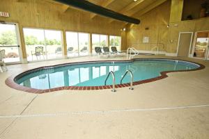 a large swimming pool in a building with a large room at Crown Pointe Lodge; BW Signature Collection in Farmington