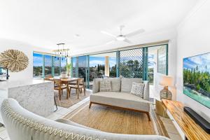 a living room filled with furniture and a large window at The Norfolks on Moffat Beach in Caloundra