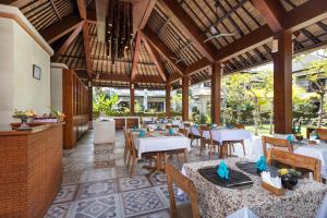 a restaurant with tables and chairs in a room at Radha Phala Resort & Spa in Ubud