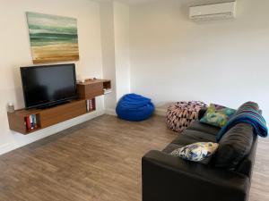 Uma TV ou centro de entretenimento em Sunnyside - Surf Side, Linen and Wifi included