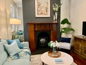 a living room with a couch and a fireplace at Warders Cottage: Iconic Cottage in the Heart of Freo in Fremantle