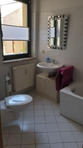 a bathroom with a toilet and a sink and a tub at Ferienwohnung Neustrelitz in Neustrelitz
