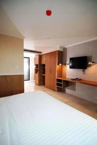 a bedroom with a large bed and a flat screen tv at Bourbon St. Boutique Hotel in Bangkok