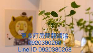 a picture of a teddy bear with flowers in vases at 宜蘭羅東迷彩民宿-大吉迷彩 in Luodong