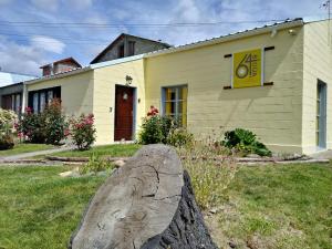 a house with a large rock in front of it at Hostel House 64Bigüa in El Calafate