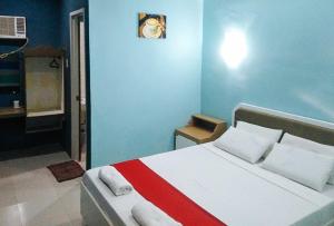 a bedroom with a bed with a blue wall at RedDoorz at EM Pensiontel Butuan City in Butuan +16 photos
