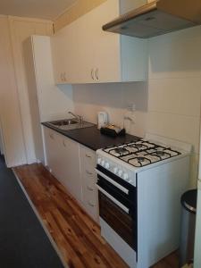 a small kitchen with a stove and a sink at Whyalla Country Inn Motel in Whyalla