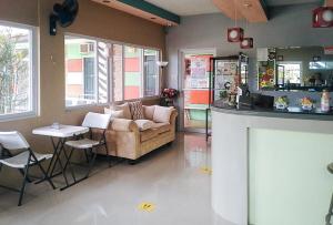 een woonkamer met een bank en een tafel bij RedDoorz@EM Pensiontel Butuan City in Butuan