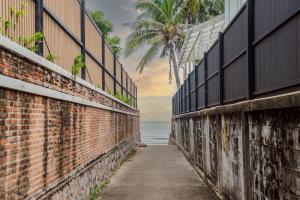 eine Backsteinmauer mit dem Ozean im Hintergrund in der Unterkunft White beach house Hua hin 20 second to the beach in Hua Hin