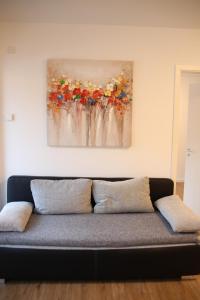 um sofá num quarto com uma pintura na parede em Casa Kronengarten Nr 2 em Hilden