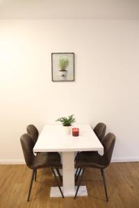 uma mesa branca com cadeiras e uma planta sobre ela em Casa Kronengarten Nr 2 em Hilden