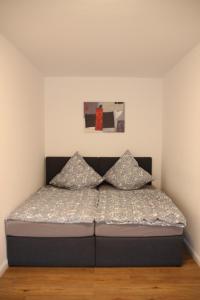 uma cama com duas almofadas num quarto em Casa Kronengarten Nr 2 em Hilden