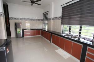 a large kitchen with red and white walls and a ceiling at Dca villa homestay in Kota Bharu