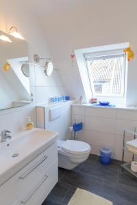 een badkamer met een toilet, een wastafel en een raam bij Revenstorf Wohnung 2 in Grömitz