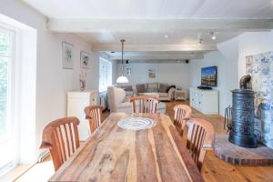 uma cozinha e sala de estar com uma mesa de madeira e cadeiras em Wellnesswarft Waygaard West em Dagebüll
