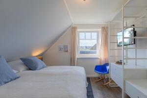 een slaapkamer met 2 bedden en een raam bij Nordwind in Braderup