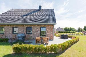 een stenen huis met een tafel en stoelen in een tuin bij Nordwind in Braderup