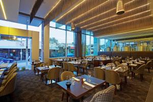 restauracja ze stołami, krzesłami i oknami w obiekcie Hotel 115 w Melbourne