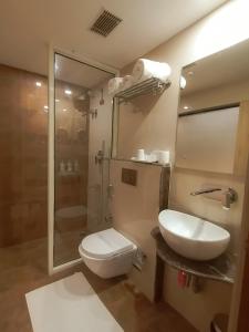a bathroom with a toilet and a sink and a shower at Ghar 365 Residency in Guwahati