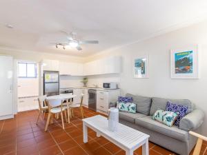 a living room with a couch and a table at Copacabana 2 cute unit with water views from the balcony in Corlette