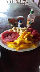 a plate of food with fruit and chips on a table at Bananas Guest House Private Room in Altagracia