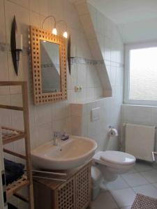 La salle de bains est pourvue d'un lavabo et de toilettes. dans l'établissement Ferienhaus im Kanalblick, à Osterrönfeld