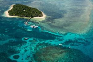 an island in the ocean with a boat in it at Coral Tree Inn in Cairns