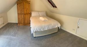 a small bedroom with a bed in a attic at Beautiful 6 Bedroom with spacious Lounge & Rooms Free parking in Erith