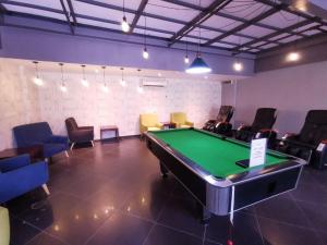 a room with a pool table and some chairs at Amansari Residence Resort in Johor Bahru