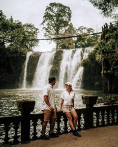 a man and a woman standing in front of a waterfall at Coral Tree Inn in Cairns