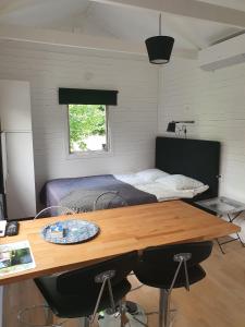 a bedroom with a bed and a wooden table with chairs at Skogsbäckens stugby AB in Tomelilla