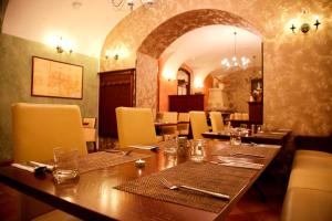 Hotel Zamek Berchtold في Strančice: غرفة طعام مع طاولة وكراسي خشبية كبيرة